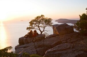 Couple sitting on cliff in front of Marmara sea, Prince island, Istanbul, Turkey