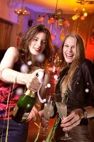 Two happy woman celebrating New Year with champagne