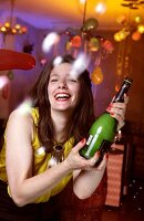 Portrait of happy woman wearing yellow top celebrating New Year's with champagne, smiling