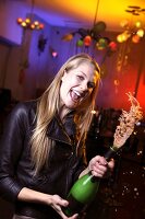 Portrait of happy woman wearing leather jacket celebrating New Year's with champagne