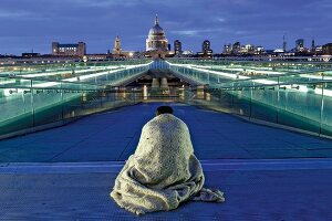 Rear view of man on Millennium Bridge, Tate Modern and St Paul's Cathedral at London, UK