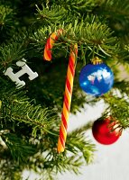 Close-up of Christmas tree decorated with candy canes, baubles and lit candles