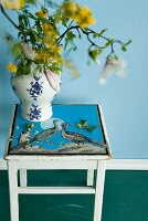 Vase on stool decorated with peacock motif decoupage