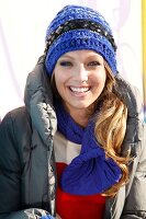 Portrait of happy blonde woman wearing winter jacket and hat, laughing