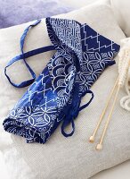 Knitting and crochet needles in blue and white fabric needle case