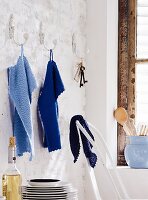 Blaue gestrickte Handtücher hängen an Wandhaken