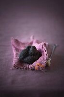 A black truffle mushroom on a piece of pink fabric