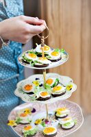 Fried eggs on pieces of pumpernickel on a cake stand