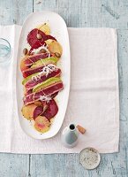 Tuna carpaccio with beetroot and golden beets on a white plate