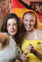 Portrait of two ecstatic women at a football game with Germany flag in background