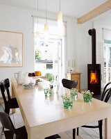 Dining room with wooden burning stove, dining table made of birch wood and plywood
