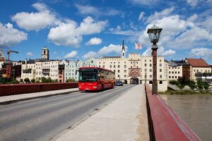 Woman walking on street in front of Wasserburg am Inn in Rosenheim, Bavaria, Germany