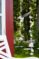 Wind chimes made from seashells & feathers hanging outside summer house