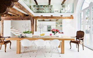 Open-plan interior with wood-beamed ceiling, mezzanine, kitchen & dining area
