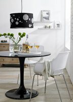 Black lamp with checked points, table, vase, glass and drink