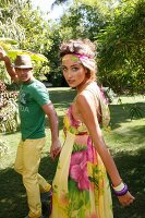 Couple wearing colourful summer outfit having fun in garden