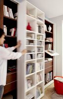 Woman moving white wooden shelf, blurred motion