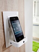 Phone on dock speaker on wooden panel in bathroom