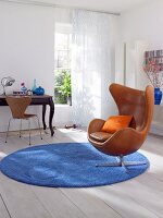 Living room with brown armchair and desk on blue rug