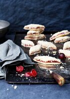 Crumbly marzipan and cherry biscuits on a baking tray