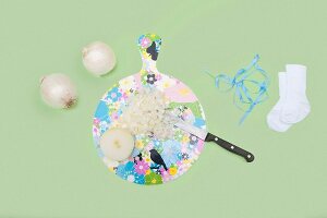 Whole, halved and chopped onions with board, knife, socks and blue ribbon