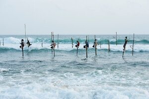 Stilt fishermen in Indian Ocean at Weligma on the south coast of Sri Lanka