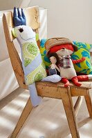 Cushions and stuffed dolls on a wooden chair