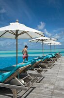 Parasol at swimming pool in front of sea, Dhigufinolhu island, Maldives