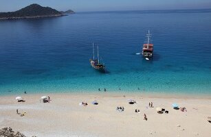 People and two ships at Kaputas beach in Turkey