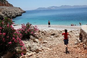 People on beach with mountain ranges in background, Aegean, Turkey