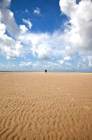 Person walking on the rippled sand at Fano beach, Denmark