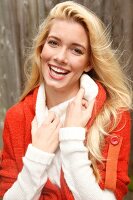 Portrait of beautiful blonde woman with long hair in white and orange cardigan, smiling
