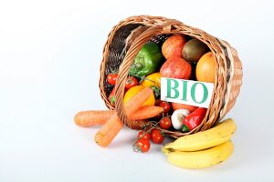 Basket of fruit and vegetables on white background