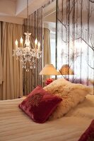 Bed and chandelier in bedroom of hotel in Oslo, Norway