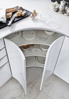 Kitchen cabinet with round doors and cutlery in it