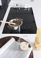 Saucepan with wooden spoon on induction hob