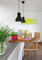 A seating area with bar stool and a pendant lamp at a modern kitchen island