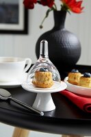Muffins mit Heidelbeeren,Tee auf Tisch in schwarz, schwarze Vase