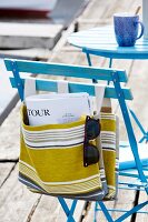 Striped linen bag hanging on blue chair