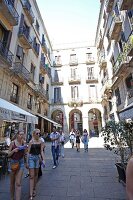 Tourist at Placa Reial alley near sidewalk cafe in Barcelona, Spain
