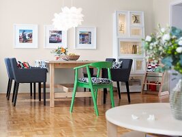 Dining room with dining table, chair, chandelier and picture frames on wall