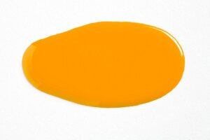  Close-up of dab of yellow nail polish on white background 