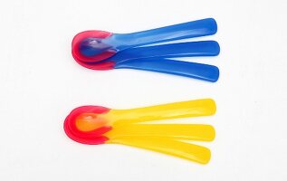 Colourful heat sensor spoons on white background