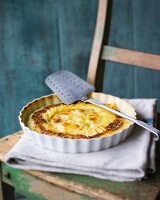 Potato gratin in a baking dish on a chair