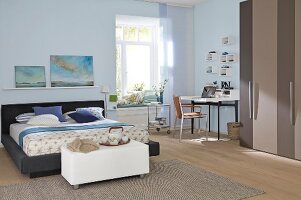 View of bedroom with home office secretary desk in front of window seating