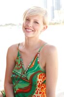 Blonde woman with short hair in a green dress on the beach