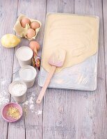 Sponge cake mixture being spread onto a baking tray