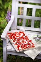 Strawberry tray bake cake outside on a garden bench