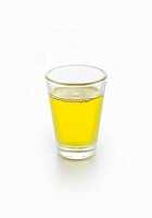 Ein Glas Moringaöl vor weißem Hintergrund