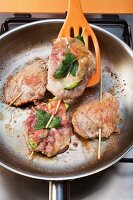 Saltimbocca being fried in a pan